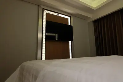 a bedroom with a bed and a flat screen tv at Wirton Seminyak in Denpasar