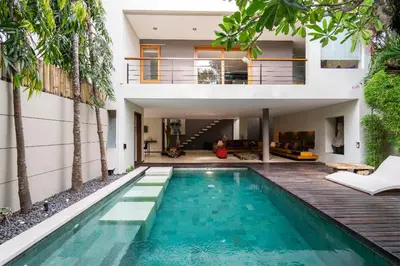 a house with a swimming pool in front of a house at Villa Athena in Seminyak