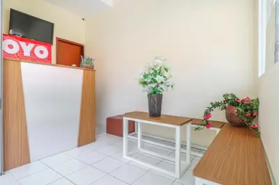 a waiting room with a table with flowers on it at Hotel O Nan Berlian Inn in Legian