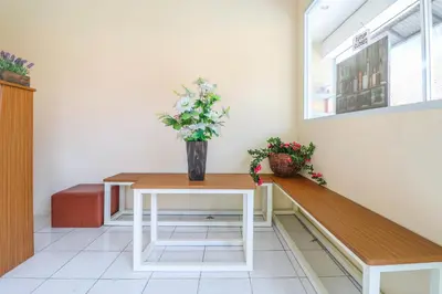 a vase of flowers sitting on a table in a room at Hotel O Nan Berlian Inn in Legian