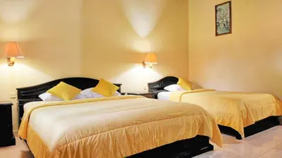 a hotel room with two beds with yellow sheets at Masainn Hotel Kuta in Kuta