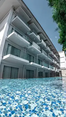 a building with a swimming pool in front of it at The Capital Hotel and Resort Seminyak in Seminyak