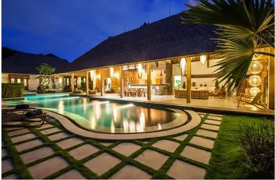 a swimming pool in front of a house at Villa Katapappa in Seminyak
