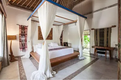 a bedroom with a bed with a mosquito net at Villa Katapappa in Seminyak