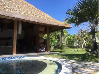 a house with a swimming pool next to a resort at Villa Katapappa in Seminyak