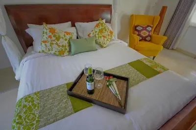 a bed with a tray with two drinks and a chair at UMA LIMA VILLA - 7Min Beach Access - 10min to Canggu in Canggu
