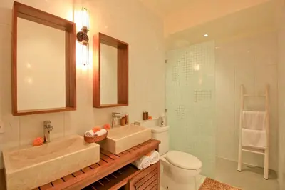 a bathroom with two sinks and a shower and a toilet at UMA LIMA VILLA - 7Min Beach Access - 10min to Canggu in Canggu