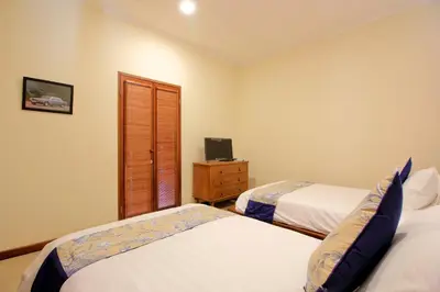 a bedroom with two beds and a television in it at UMA LIMA VILLA - 7Min Beach Access - 10min to Canggu in Canggu