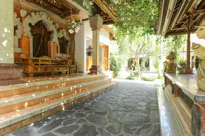 a house with a stone walkway in front of a building at The Legian Mas Beach Inn in Kuta