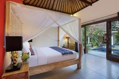 a bedroom with a bed and a tv in a room at Villa Agni - BEST location! 3BR villa at the heart of Seminyak in Seminyak