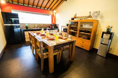 a kitchen with a wooden table with chairs and drinks on it at Villa Agni - BEST location! 3BR villa at the heart of Seminyak in Seminyak