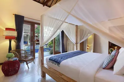 a bedroom with a large bed with a canopy at Villa Agni - BEST location! 3BR villa at the heart of Seminyak in Seminyak