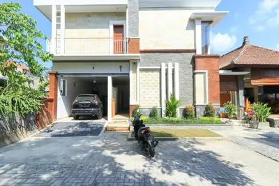 a motorcycle parked in front of a house at Manu Guest House 2 in Canggu
