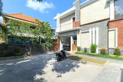 a motorcycle parked in front of a house at Manu Guest House 2 in Canggu