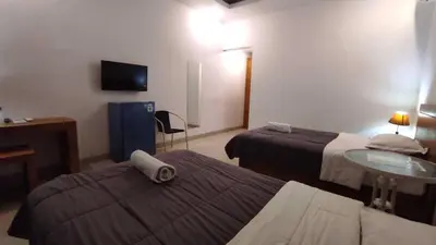 a hotel room with two beds and a tv at Manu Guest House 2 in Canggu
