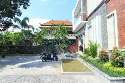a motorcycle parked in front of a house at Manu Guest House 2 in Canggu