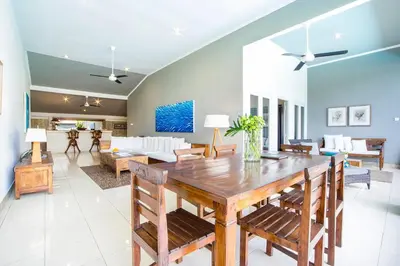 a dining room and living room with a table and chairs at Premium Villas Seminyak I in Seminyak