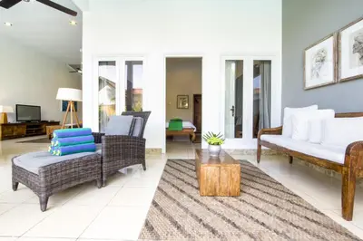 a living room with wicker chairs and a couch at Premium Villas Seminyak I in Seminyak