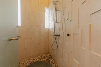 a bathroom with a shower with a door and a window at Taman Mesari Luxury Villas-Seminyak in Seminyak