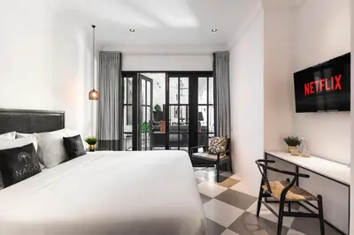 a bedroom with a large white bed and a desk at Villa Nago Walk to Seminyak Best Spots in Seminyak