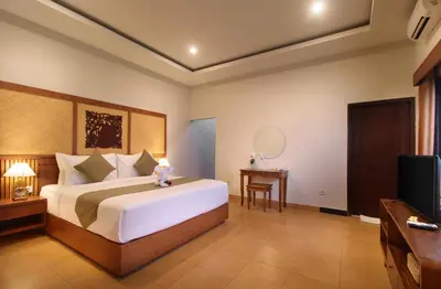 a bedroom with a large bed and a television at Sudha Villa Bali B in Seminyak