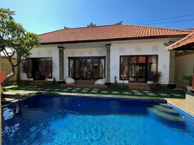 a swimming pool in front of a house at Villa Margherita in Seminyak