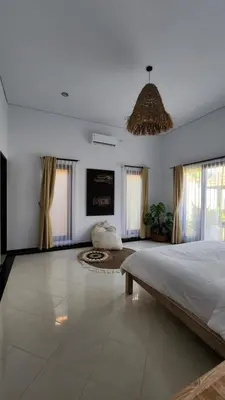 a large bedroom with a large bed and windows at Villa Margherita in Seminyak