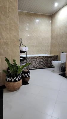 a bathroom with a toilet and a potted plant at Villa Margherita in Seminyak