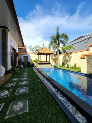 a swimming pool in the yard of a house at Villa Margherita in Seminyak