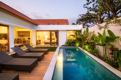 a backyard with a swimming pool and a house at Taman Sari Pengubengan Villa in Kerobokan