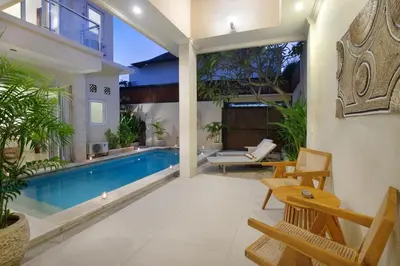 an indoor swimming pool in a villa with a patio at Villa Maleena in Seminyak