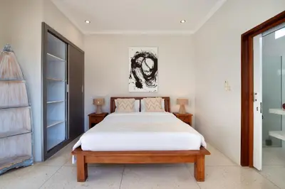 a bedroom with a large bed with white sheets at Villa Maleena in Seminyak