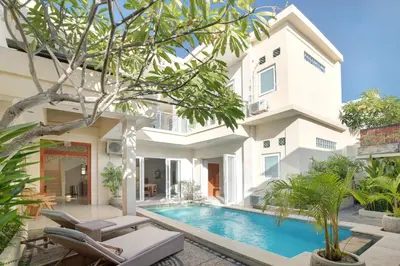 a villa with a swimming pool in front of a building at Villa Maleena in Seminyak