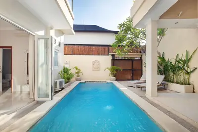 a swimming pool in a villa with a house at Villa Maleena in Seminyak
