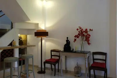 a living room with chairs and a table and a lamp at Villa Celavi 77 in Jimbaran