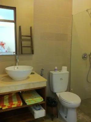 a bathroom with a sink and a toilet and a mirror at Villa Celavi 77 in Jimbaran
