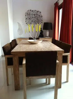 a wooden table with chairs and a dining room at Villa Celavi 77 in Jimbaran