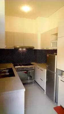a kitchen with white cabinets and a stainless steel stove at Villa Celavi 77 in Jimbaran