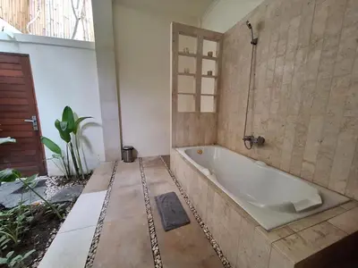 a bathroom with a bath tub in a room at Villa Beji in Seminyak