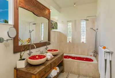 a bathroom with two sinks and a tub and a mirror at Villa Beji in Seminyak