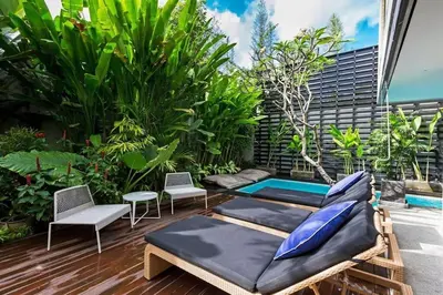 a patio with two beds and a swimming pool at Villa C99 Seminyak in Kerobokan