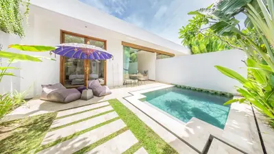 a villa with a swimming pool and an umbrella at Anema Villa Seminyak in Legian