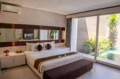 a bedroom with a large bed and a swimming pool at Asa Bali Luxury Villas & Spa in Seminyak