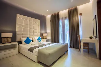 a bedroom with a large bed with blue pillows at Villa Orange 3BR Seminyak by Exotic Bali Properties in Seminyak