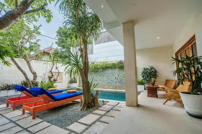 a patio with a blue and red couch and a tree at Villa Orange 3BR Seminyak by Exotic Bali Properties in Seminyak