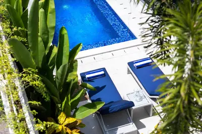 two blue lounge chairs and a swimming pool at Summer House Villa in Canggu