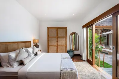 a bedroom with a large bed and a sliding glass door at Villa Loma by Alfred in Bali in Seminyak