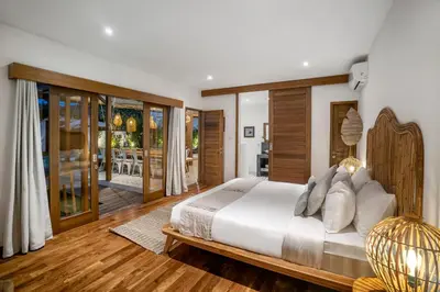 a bedroom with a large bed and a living room at Villa Loma by Alfred in Bali in Seminyak