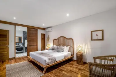 a bedroom with a large bed with a wooden headboard at Villa Loma by Alfred in Bali in Seminyak