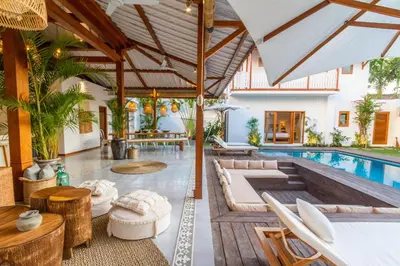 an outdoor living room with a pool and a villa at Villa Loma by Alfred in Bali in Seminyak